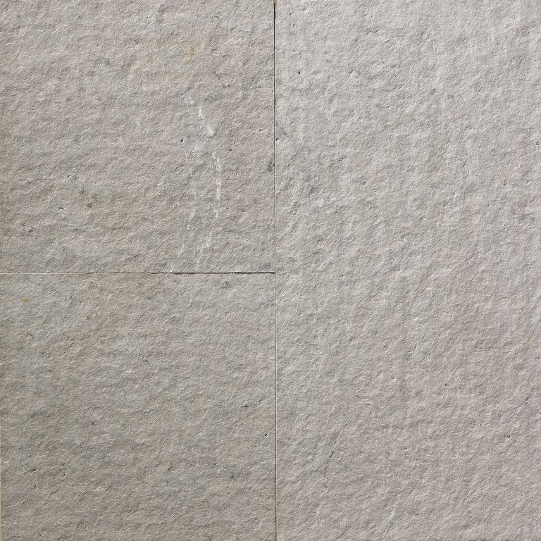 Feature image for Greyflek Limestone. The surface finish shown is flamed. The dominant color shown is gray; with beige, blue, brown, orange/rust, purple, tan and cream secondaries. The color mix creates a warm feeling. Regular color pattern. Contains mineral inclusions.
