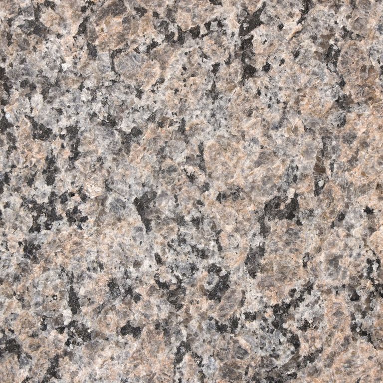 Feature image for Granite - Autumn Brown. The surface finish shown is flamed. The dominant color shown is pink; with beige, brown, green, orange/rust, pink, purple, white, tan and cream secondaries. The color mix creates a warm feeling. Coarse speckled color pattern. Contains some mica and mineral inclusions.