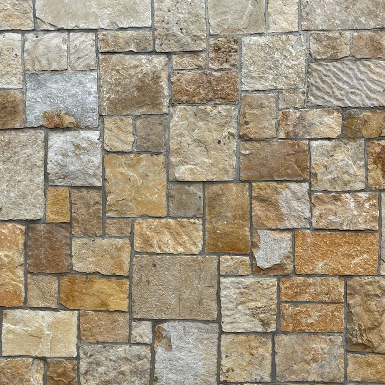 Application image for South Bay Quartzite. The image shows this material being used for full bed veneer and thin veneer. The surface finish shown is split-face with flat plane. Dominant colors shown are brown and tan; with beige, gray and orange/rust secondaries. The color mix creates a warm feeling.
