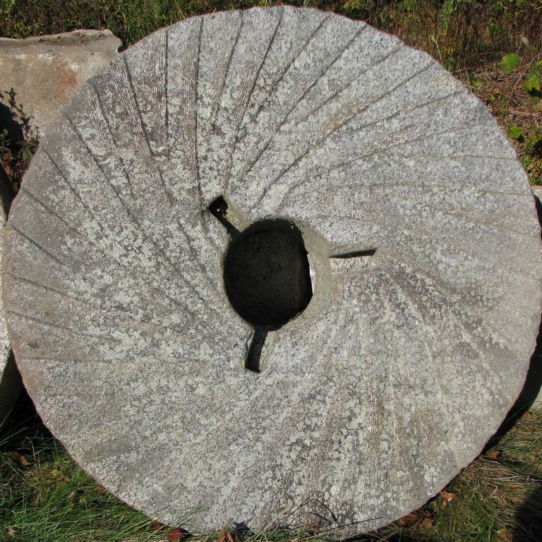 Application image for Granite - Reclaimed Antique Farm and Mill Stones. The image shows this material being used for architectural elements and garden accents. The surface finish shown is . The dominant color shown is gray; with beige, green, purple and white secondaries. Regular color pattern.