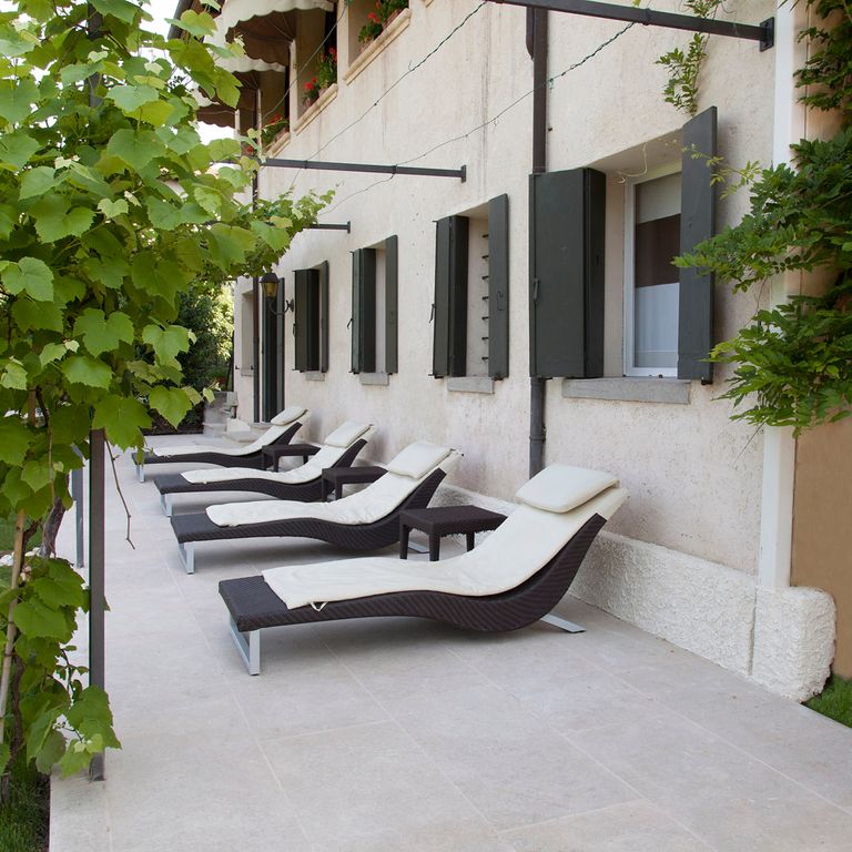 Feature image for Veneto Beige Limestone - Pavers. The image shows this product being used in a patio pavers application. The surface finish shown is . Dominant colors shown are beige, tan and cream. The color mix creates a warm feeling.