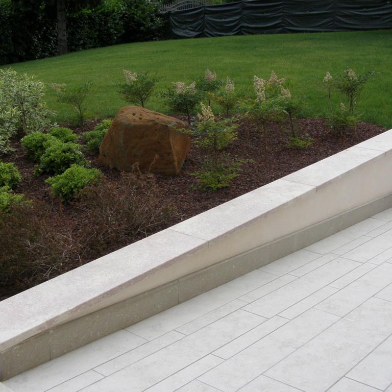 Application image for Veneto Olivo Limestone - Pavers. The image shows this product being used in a patio pavers application. The surface finish shown is flamed. Dominant colors shown are beige and gray; with beige and white secondaries. The color mix creates a warm feeling. Cloudy color pattern. Contains mineral inclusions.