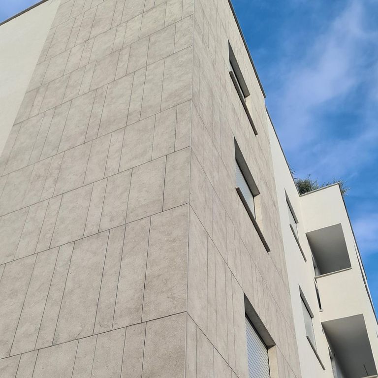Application image for Veneto Olivo Limestone - Veneer. The image shows this product being used in a full bed veneer application. The surface finish shown is bush hammered. Dominant colors shown are gray and tan. The color mix creates a cool feeling.