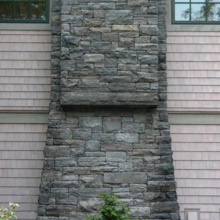 Application image for Granite - Mystic Mountain- Splitface Veneer. The image shows this product being used in a full bed veneer application. The surface finish shown is split-face. Dominant colors shown are green and gray. Exhibits 