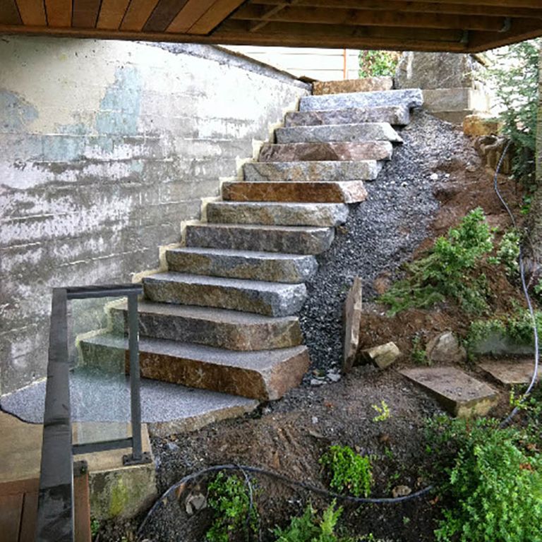 Application image for New England Fieldstone Boulders - Sawn Steps. The image shows this product being used in a monolithic steps application. This is a landscape stone for outdoor commercial and residential applications. Suitable for general use, freeze-thaw conditions, high traffic areas, low slipperiness surfaces and high heel compatibilty situations. Higher to high on the price spectrum.