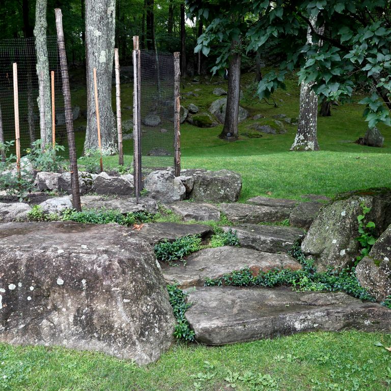 Application image for New England Fieldstone Boulders - Sawn - Live Edge Step. The image shows this product being used in a monolithic steps application. Dominant colors shown are black and gray.