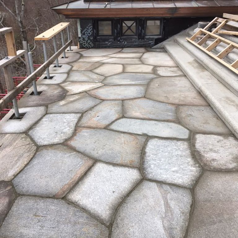 Application image for New England Fieldstone Boulders - Sawn Pavers. The image shows this product being used in a patio pavers application. The surface finish shown is sawn. The dominant color shown is gray; with beige, pink, purple, white, tan and cream secondaries. Exhibits 