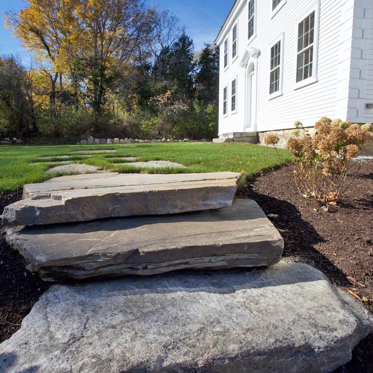 Application image for New England Fieldstone Steppers and Steps. The image shows this product being used in a monolithic steps application. This is a landscape stone for outdoor commercial and residential applications. Suitable for general use, freeze-thaw conditions, high traffic areas and low slipperiness surfaces situations. Moderate to higher on the price spectrum.