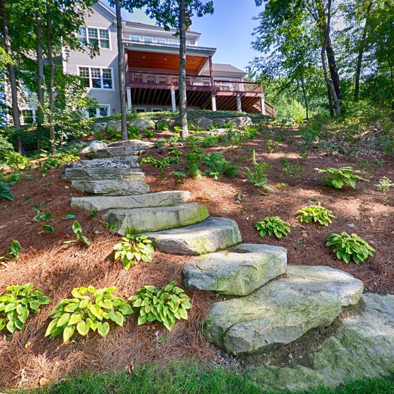 Application image for New England Fieldstone Steppers and Steps. The image shows this product being used in a monolithic steps application. This is a landscape stone for outdoor commercial and residential applications. Suitable for general use, freeze-thaw conditions, high traffic areas and low slipperiness surfaces situations. Moderate to higher on the price spectrum.