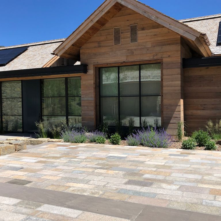 Feature image for Reclaimed Footworn Granite - Plank Pavers. The image shows this product being used for driveway pavers and patio pavers. The surface finish shown is . Dominant colors shown are beige, gray, tan and cream; with beige, pink, purple, white, tan and cream secondaries. Exhibits 