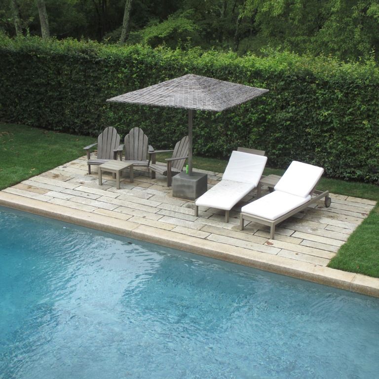 Application image for Reclaimed Footworn Granite - Plank Pavers. The image shows this product being used for pool coping and pool deck pavers. The surface finish shown is . Dominant colors shown are beige, gray and cream; with gray, white and tan secondaries. The color mix creates a warm feeling. Regular and speckled color patterns.
