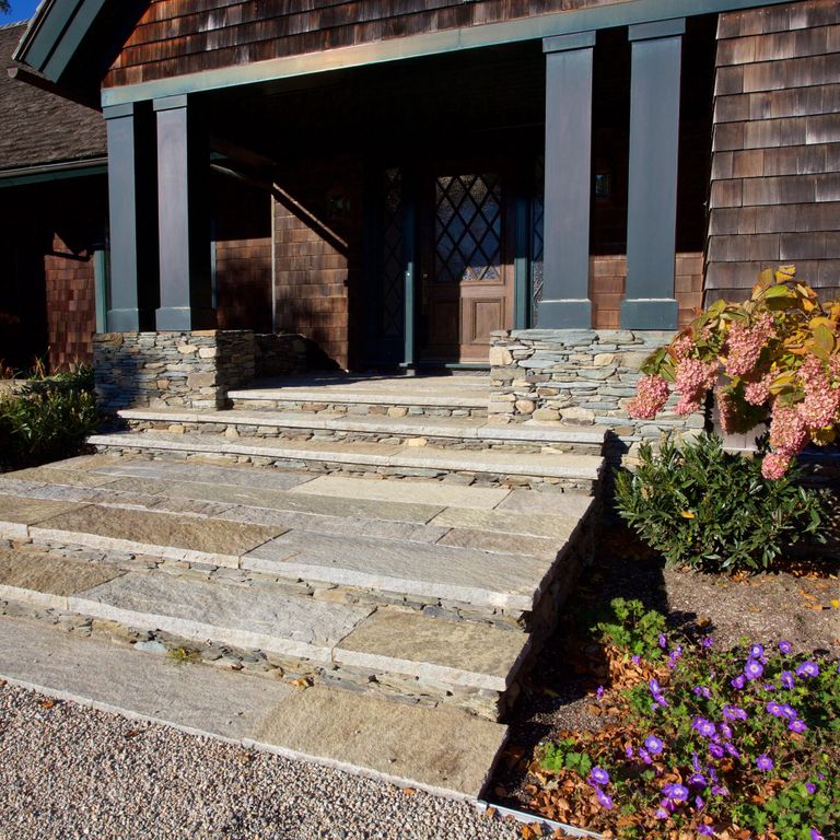Feature image for Reclaimed Granite Treads - Weathered Riser and Tread. The image shows this product being used in a treads application. Dominant colors shown are beige, brown, gray and tan; with orange/rust and cream secondaries. The color mix creates a warm feeling. Random, speckled, blotched and cloudy color patterns.