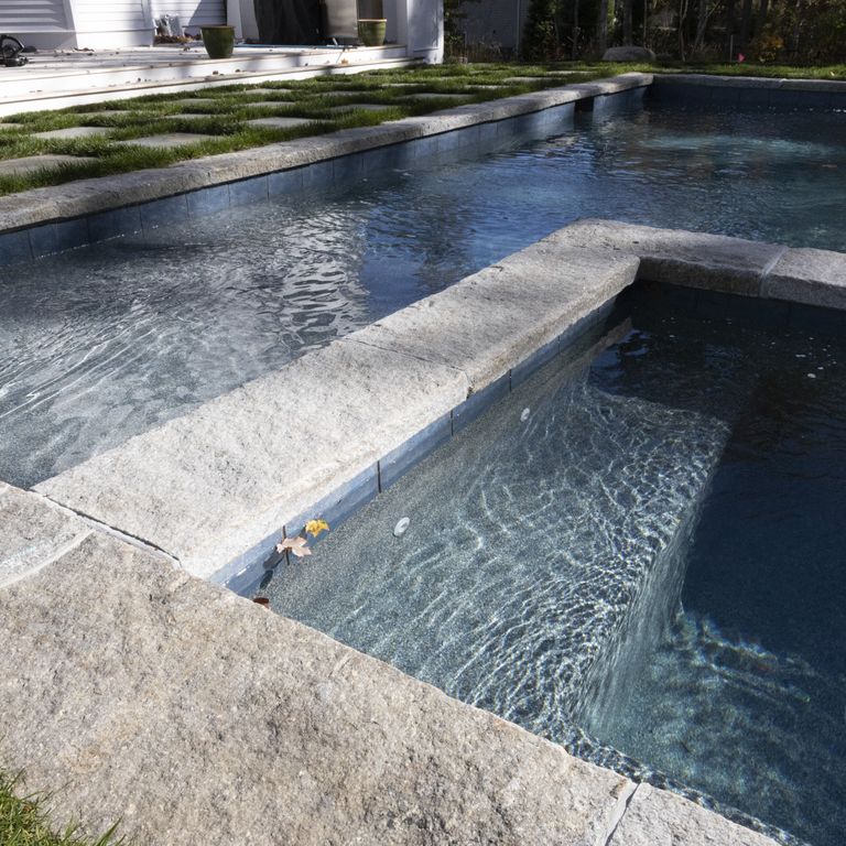 Application image for Granite - Reclaimed Curbstone - Pool Coping. The image shows this product being used in a pool coping application. Dominant colors shown are beige and gray.