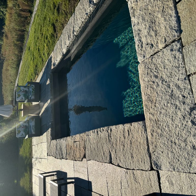 Application image for Granite - Reclaimed Curbstone - Pool Coping. The image shows this product being used in a pool coping application. Dominant colors shown are gray and tan. The color mix creates a cool feeling.
