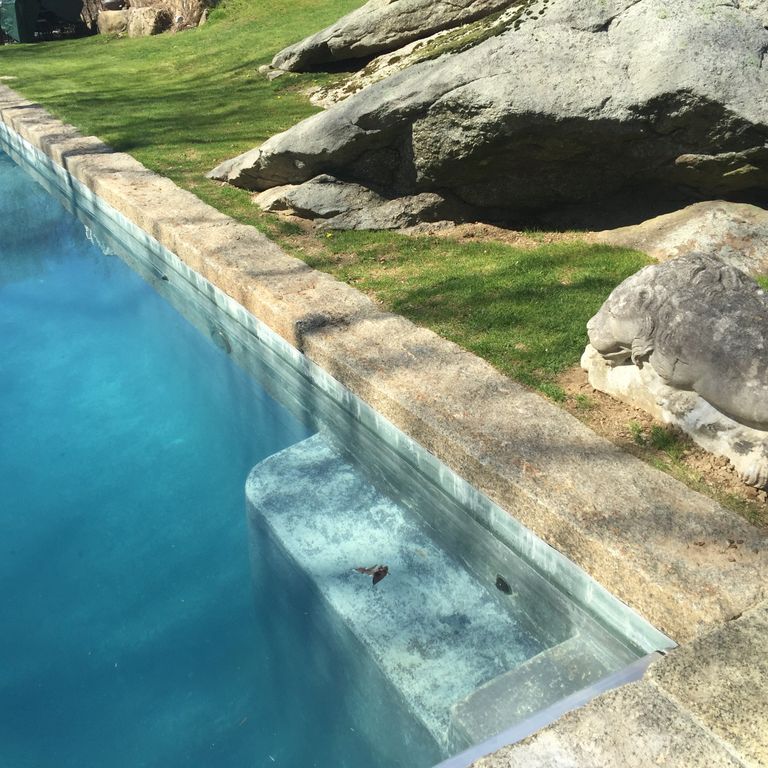 Application image for Reclaimed Granite Curbstone - Pool Coping. The image shows this product being used in a pool coping application. The surface finish shown is . The dominant color shown is gray. The color mix creates a warm feeling. Regular color pattern.