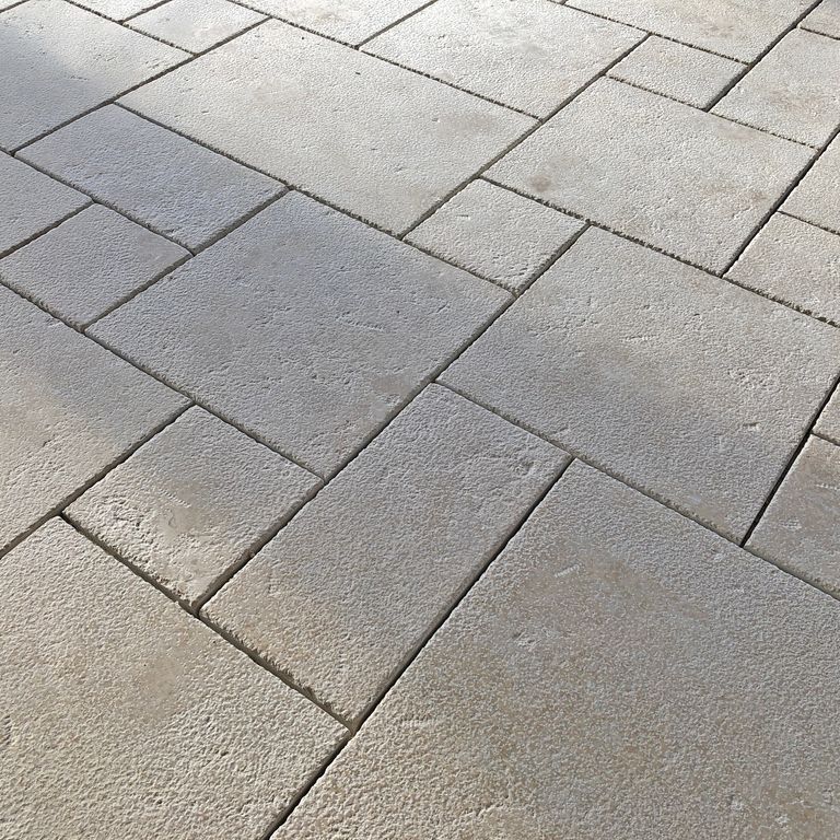Application image for Limestone - Mountain Hard Beige - Dimensional Cut Pavers. The image shows this product being used in a patio pavers application. Dominant colors shown are gray and cream; with beige, white and tan secondaries. Solid and speckled color patterns.