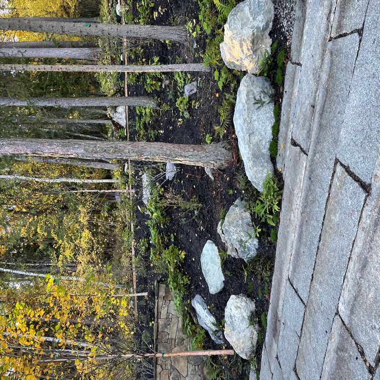 Application image for Reclaimed First Generation Granite Curbstone Plank Pavers. The image shows this product being used in a path pavers application. The surface finish shown is . The dominant color shown is brown. The color mix creates a warm feeling.