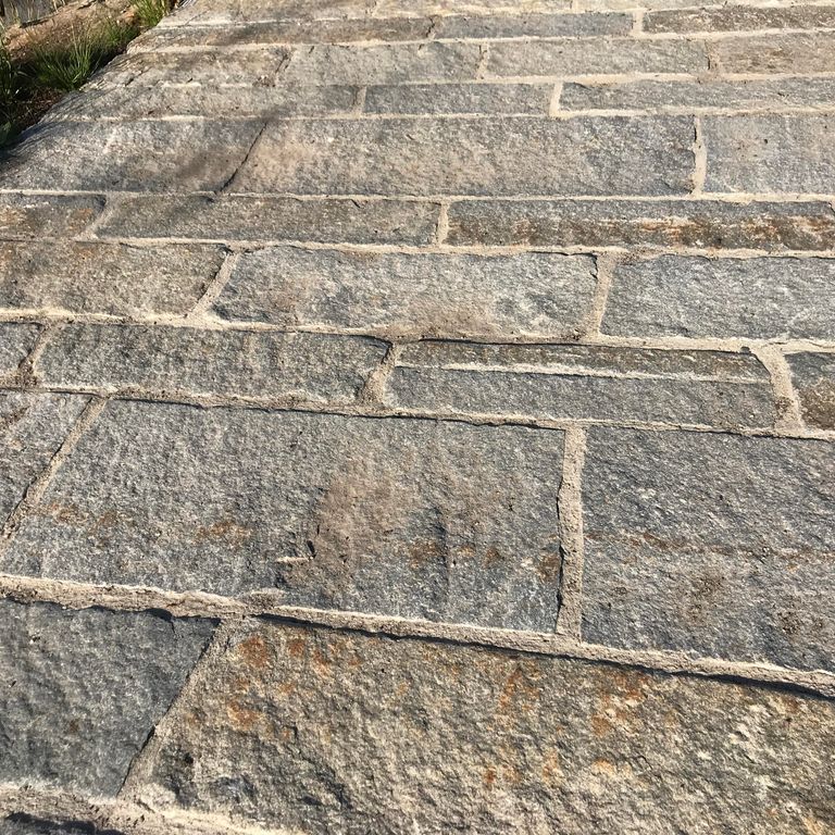 The image shows this product being used in a driveway pavers application.