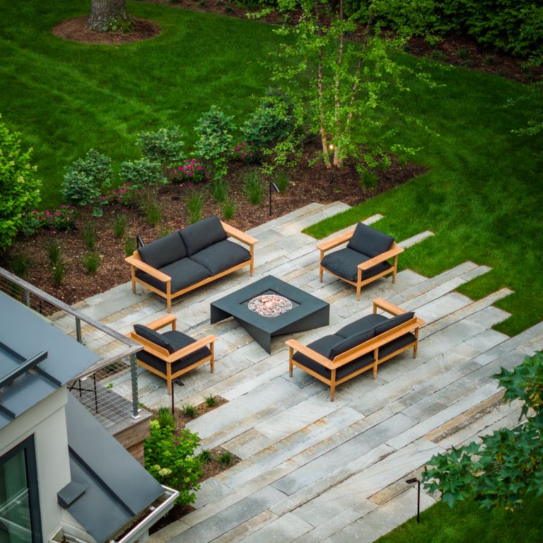 Feature image for Granite - Reclaimed Third Generation Curbstone - Plank Pavers. The image shows this product being used in a patio pavers application. The surface finish shown is . The dominant color shown is gray; with beige, blue, brown, orange/rust, white, tan and cream secondaries. The color mix creates a warm feeling. Fine speckled, blotched and random color patterns.