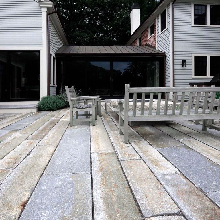 Application image for Granite - Reclaimed Third Generation Curbstone - Plank Pavers. The image shows this product being used in a patio pavers application. The surface finish shown is . The dominant color shown is gray; with beige, blue, brown, orange/rust, white, tan and cream secondaries. The color mix creates a warm feeling. Fine speckled, blotched and random color patterns.