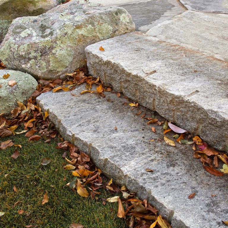 Application image for Reclaimed Second Generation Granite Curbstone Steps - Split Face Riser. The image shows this product being used in a monolithic steps application. This is a landscape stone for outdoor commercial and residential applications. Suitable for general use, freeze-thaw conditions, low heat absorption surfaces, high traffic areas and low slipperiness surfaces situations. Higher to high on the price spectrum.