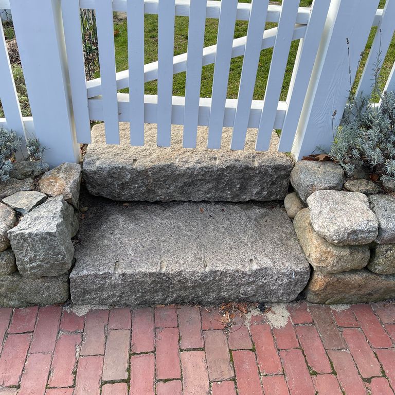 Application image for Reclaimed Second Generation Granite Curbstone Steps - Split Face Riser. The image shows this product being used in a monolithic steps application. This is a landscape stone for outdoor commercial and residential applications. Suitable for general use, freeze-thaw conditions, low heat absorption surfaces, high traffic areas and low slipperiness surfaces situations. Higher to high on the price spectrum.
