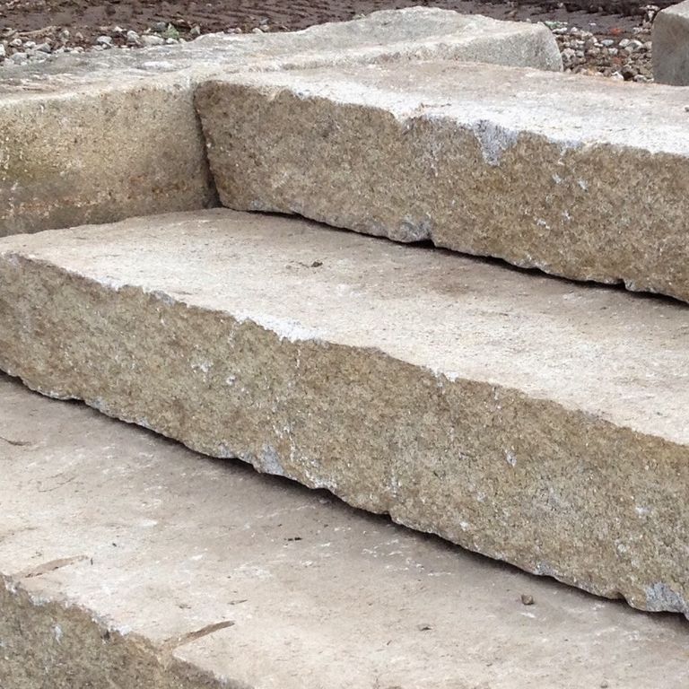 Application image for Reclaimed Second Generation Granite Curbstone Steps - Split Face Riser. The image shows this product being used in a monolithic steps application. This is a landscape stone for outdoor commercial and residential applications. Suitable for general use, freeze-thaw conditions, low heat absorption surfaces, high traffic areas and low slipperiness surfaces situations. Higher to high on the price spectrum.