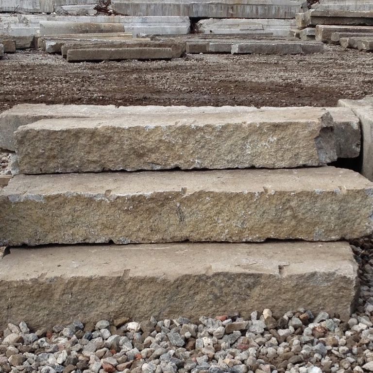 Application image for Reclaimed Second Generation Granite Curbstone Steps - Split Face Riser. The image shows this product being used in a monolithic steps application. This is a landscape stone for outdoor commercial and residential applications. Suitable for general use, freeze-thaw conditions, low heat absorption surfaces, high traffic areas and low slipperiness surfaces situations. Higher to high on the price spectrum.