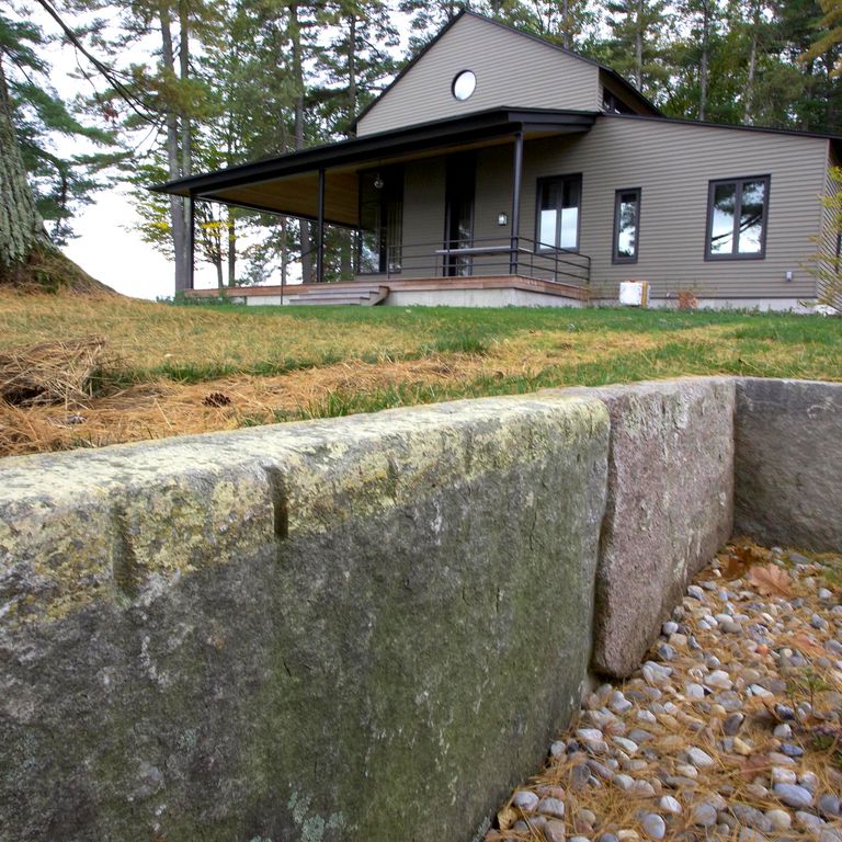 Close-up image for Reclaimed First Generation Granite Curbstone Edging. The surface finishes shown are weathered and worn. Dominant colors shown are brown, green and gray; with purple and tan secondaries. Regular, speckled and blotched color patterns.