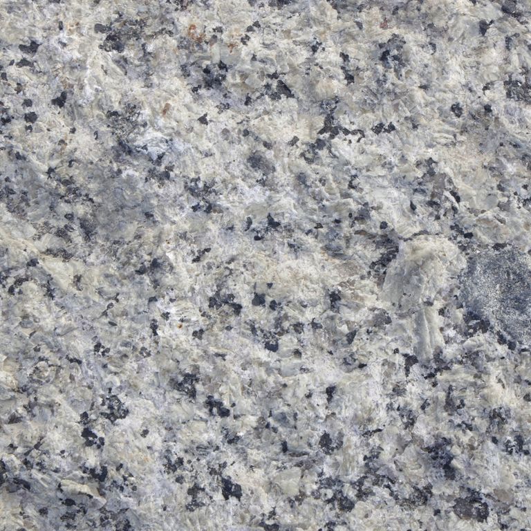 Color/Finish variation image for Reclaimed First Generation Granite Curbstone Edging. The dominant color shown is gray; with beige, blue and white secondaries. The color mix creates a cool feeling. Coarse speckled, blotched and cloudy color patterns. Contains mineral inclusions.