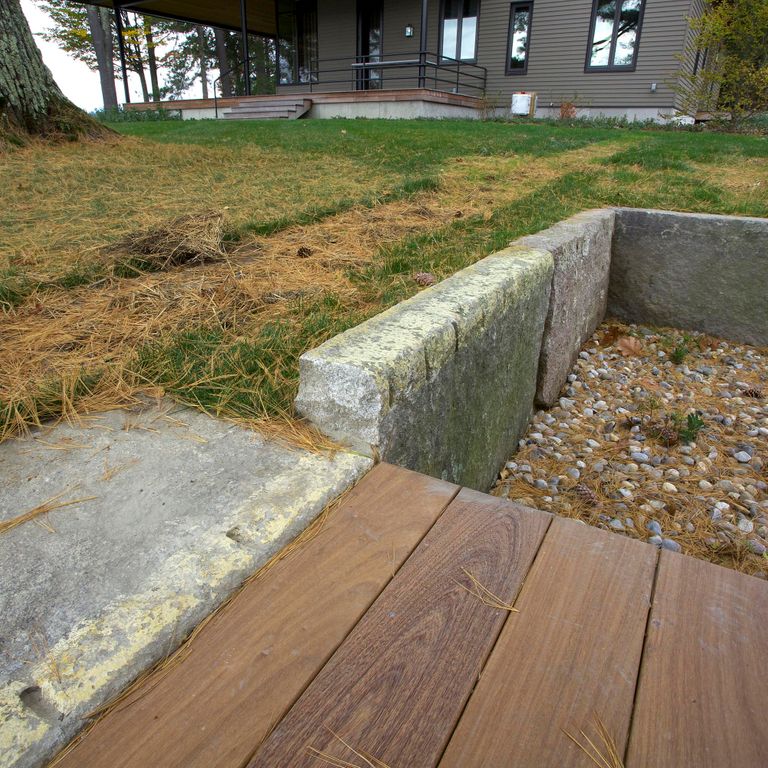 Application image for Reclaimed First Generation Granite Curbstone Edging. The image shows this product being used in a landscape curbing & edging application. This is a landscape stone for outdoor commercial and residential applications. Suitable for general use, freeze-thaw conditions, low heat absorption surfaces, high traffic areas, low slipperiness surfaces and high heel compatibilty situations. Higher to high on the price spectrum.