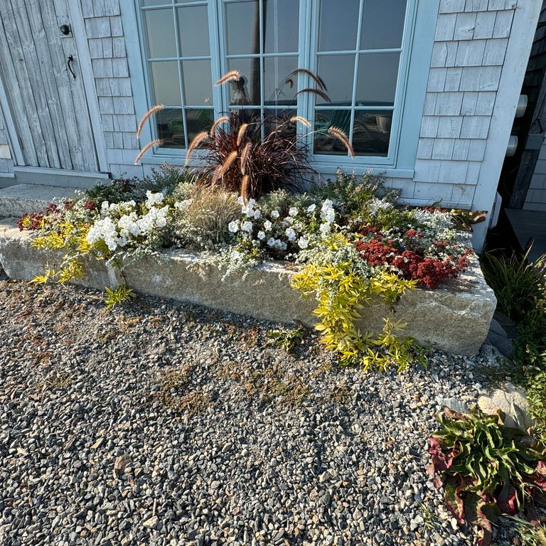 Application image for Granite - Reclaimed First Generation Curbstone - Edging. The image shows this product being used in a landscape curbing & edging application. The surface finish shown is . The dominant color shown is gray.