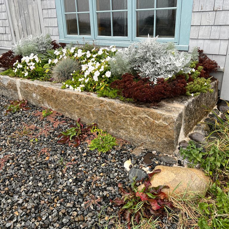 Application image for Reclaimed First Generation Granite Curbstone - Edging. The image shows this product being used in a landscape curbing & edging application. The dominant color shown is brown. The color mix creates a warm feeling.