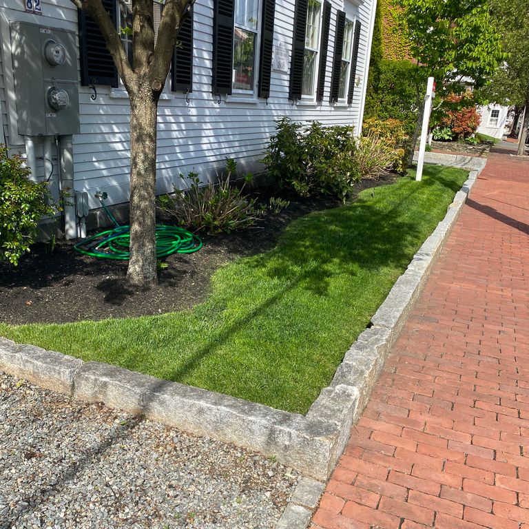 Application image for Reclaimed Granite Curbstone - Junior Edging. The image shows this product being used in a landscape curbing & edging application. This is a landscape stone for outdoor commercial and residential applications. Suitable for general use, freeze-thaw conditions, low heat absorption surfaces, high traffic areas, low slipperiness surfaces and high heel compatibilty situations. Moderate to higher on the price spectrum.
