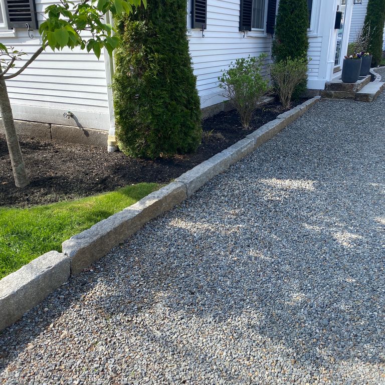 Application image for Reclaimed Granite Curbstone - Junior Edging. The image shows this product being used in a landscape curbing & edging application. This is a landscape stone for outdoor commercial and residential applications. Suitable for general use, freeze-thaw conditions, low heat absorption surfaces, high traffic areas, low slipperiness surfaces and high heel compatibilty situations. Moderate to higher on the price spectrum.