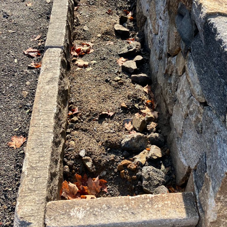 Application image for Granite - Reclaimed Curbstone - Junior Edging. The image shows this product being used in a landscape curbing & edging application. The dominant color shown is gray.