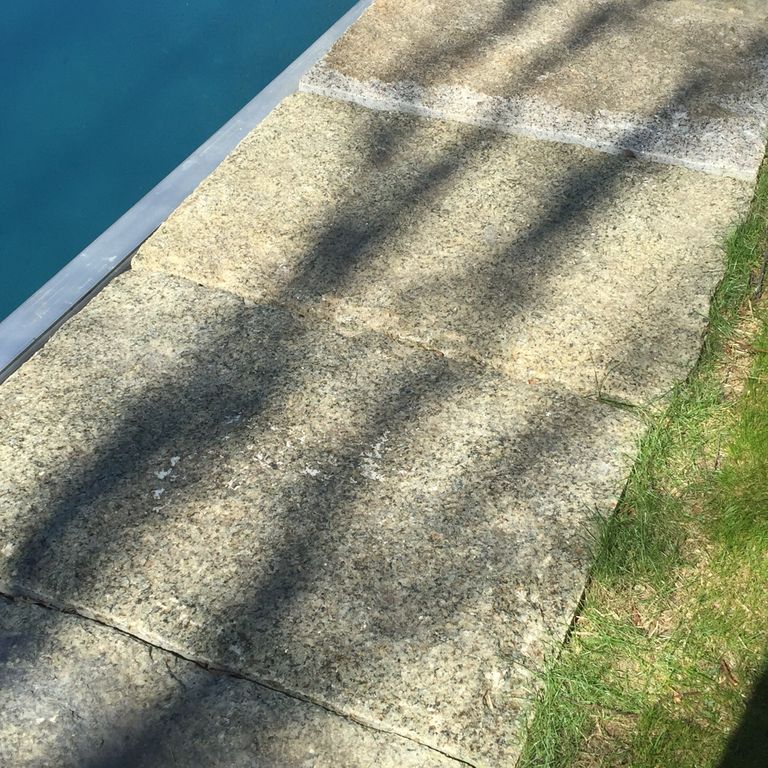 Close-up image for Reclaimed Granite Curbstone - Jumbo Pool Coping. The surface finish shown is weathered. The dominant color shown is gray. Speckled color pattern.