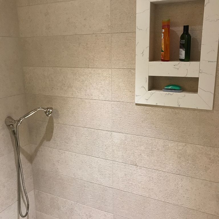 Application image for Mountain Hard Limestone Beige - Wall Veneer. The image shows this product being used in a bath tub & shower application. This is a building stone for indoor and outdoor commercial and residential applications. Suitable for general use, freeze-thaw conditions, low heat absorption surfaces, high traffic areas, low slipperiness surfaces and high heel compatibilty situations. Moderate to high on the price spectrum.