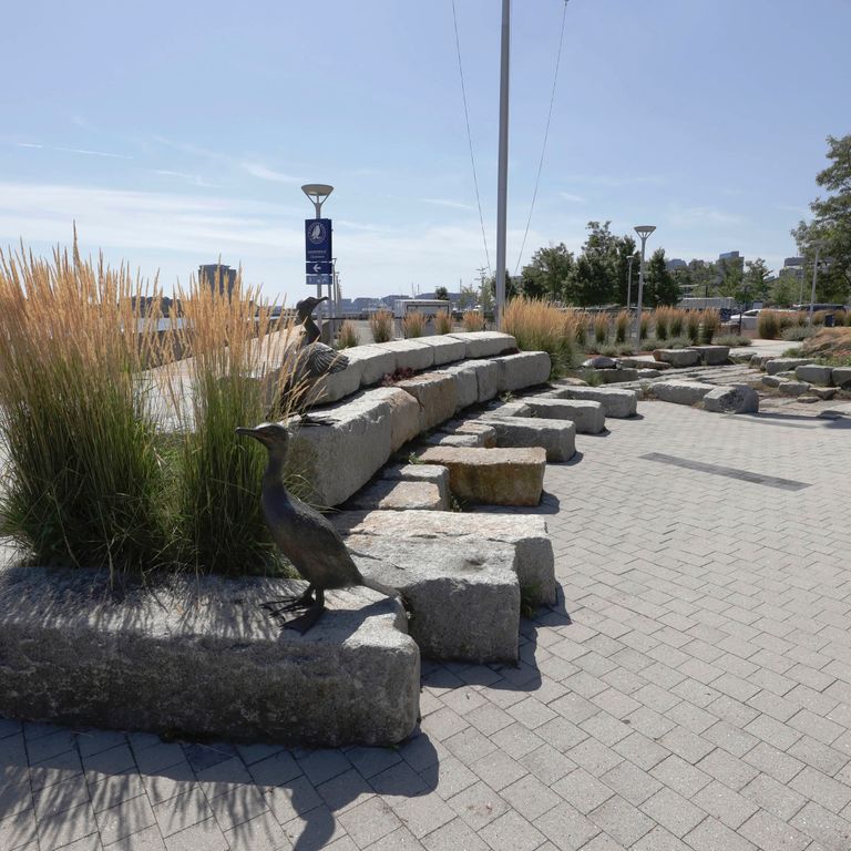 Application image for Granite - Reclaimed Block - Benches. The image shows this product being used in a seating & benches application. The surface finish shown is weathered. The dominant color shown is gray. The color mix creates a warm feeling.