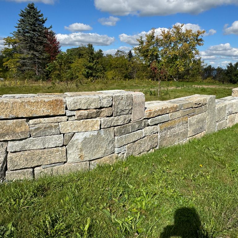 Application image for Granite - Reclaimed Block Wallstone - Block Mix. The image shows this product being used in a landscape wallstone application. The dominant color shown is brown. The color mix creates a warm feeling.