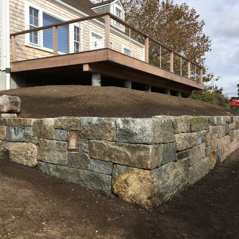 Application image for Granite - Reclaimed Block Wallstone - Block Mix. The image shows this product being used in a landscape wallstone application.
