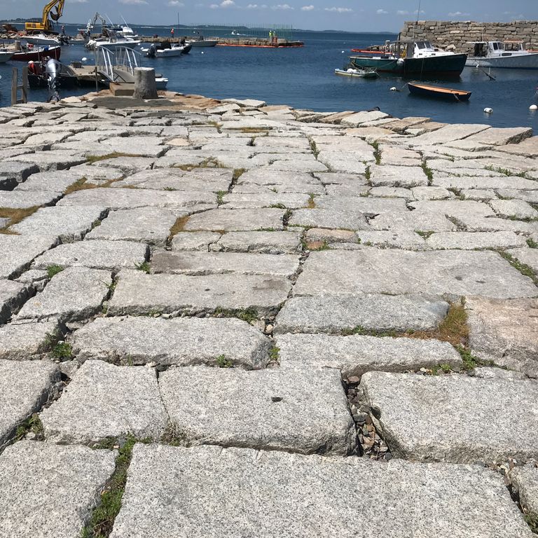 Application image for Reclaimed Granite Block - Pavers. The image shows this product being used in a patio pavers application. The surface finish shown is . The dominant color shown is gray. The color mix creates a warm feeling.