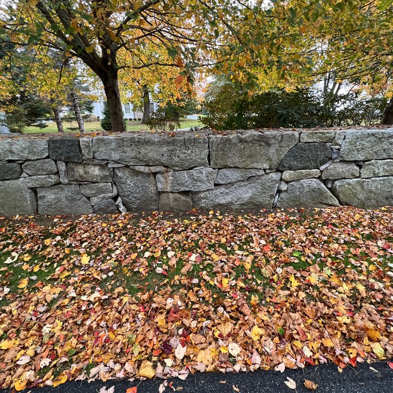 Application image for Granite - Reclaimed New England Quarry Tailings - Oversized Wallstone. The image shows this product being used in a landscape wallstone application. The dominant color shown is gray. The color mix creates a cool feeling.