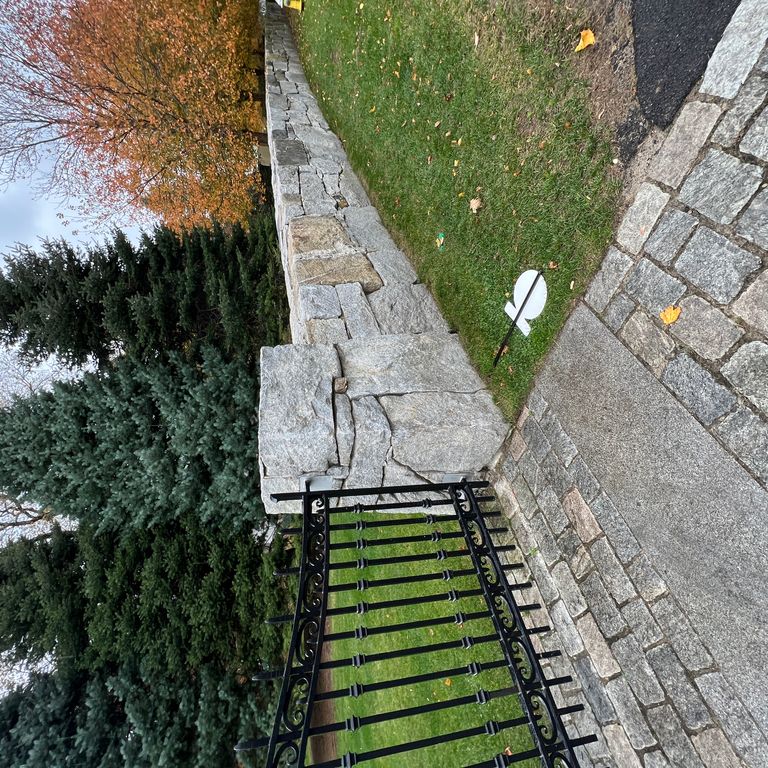 Application image for Granite - Reclaimed New England Quarry Tailings - Oversized Wallstone. The image shows this product being used in a landscape wallstone application. The dominant color shown is gray. The color mix creates a cool feeling.