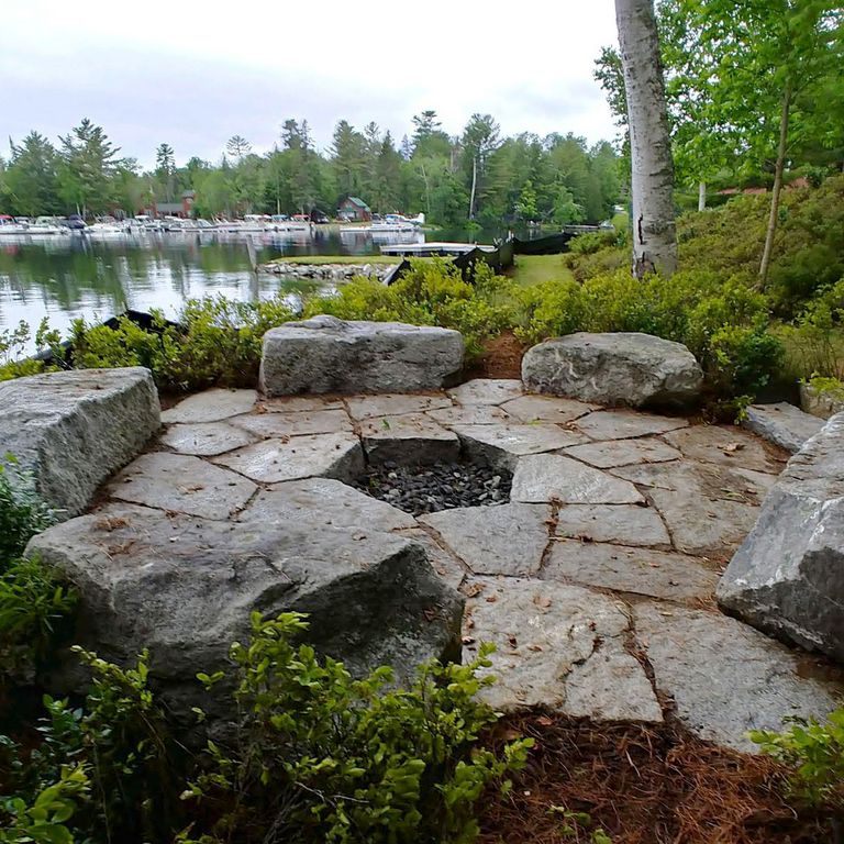 Feature image for Reclaimed New England Granite Quarry Tailings - Oversized Pavers. The image shows this product being used for seating & benches and patio pavers. The dominant color shown is gray; with blue, brown, green, purple and white secondaries. The color mix creates a cool feeling. Regular, speckled and cloudy color patterns.