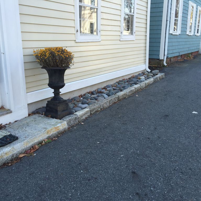 Application image for Reclaimed New England Granite Cobblestones - Jumbo Edging. The image shows this product being used in a landscape curbing & edging application. This is a landscape stone for outdoor commercial and residential applications. Suitable for general use, freeze-thaw conditions, low heat absorption surfaces, high traffic areas and low slipperiness surfaces situations. Relatively moderate in price.