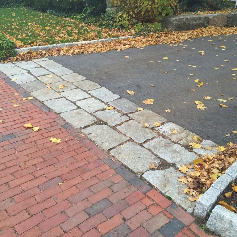 Application image for Granite - Reclaimed New England Cobblestones - Super Jumbo Pavers. The image shows this product being used in a driveway aprons application. The dominant color shown is gray.