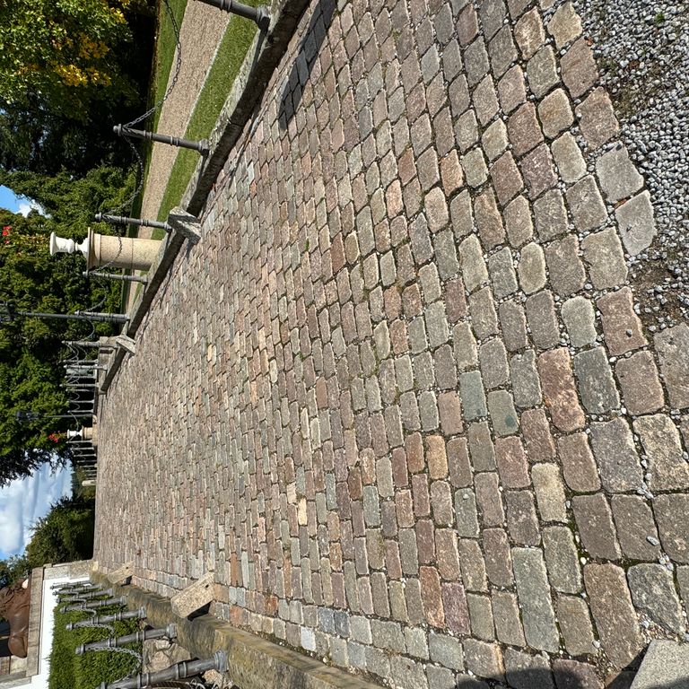 Application image for Reclaimed Swedish Granite Cobblestones - Worn Surface. The image shows this product being used in a path pavers application. The surface finish shown is . The dominant color shown is gray. The color mix creates a warm feeling.