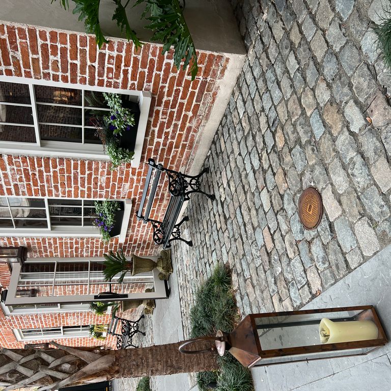 Application image for Reclaimed European Porphyry Cobblestones - Rectangle - Worn. The image shows this product being used in a path pavers application. The surface finish shown is . Dominant colors shown are black, brown and gray. The color mix creates a warm feeling.