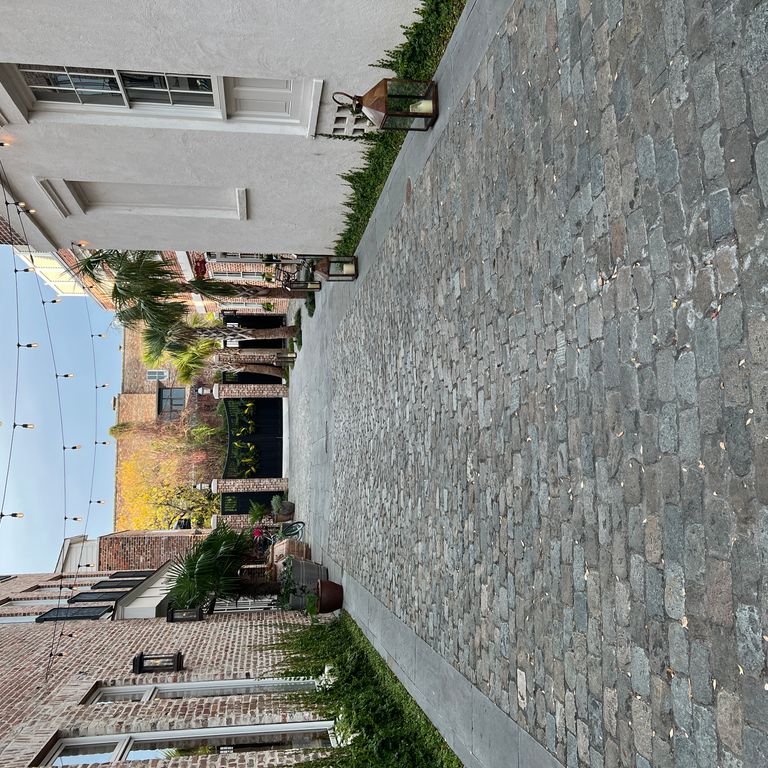 Application image for Reclaimed European Porphyry Cobblestones - Rectangle - Worn. The image shows this product being used in a path pavers application. The surface finish shown is . The dominant color shown is gray.